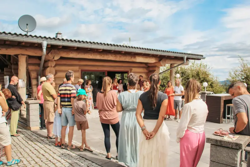 Viele Menschen stehen beim Markt der Möglichkeiten im August 2024 im Kreis vor einem Blockhaus
